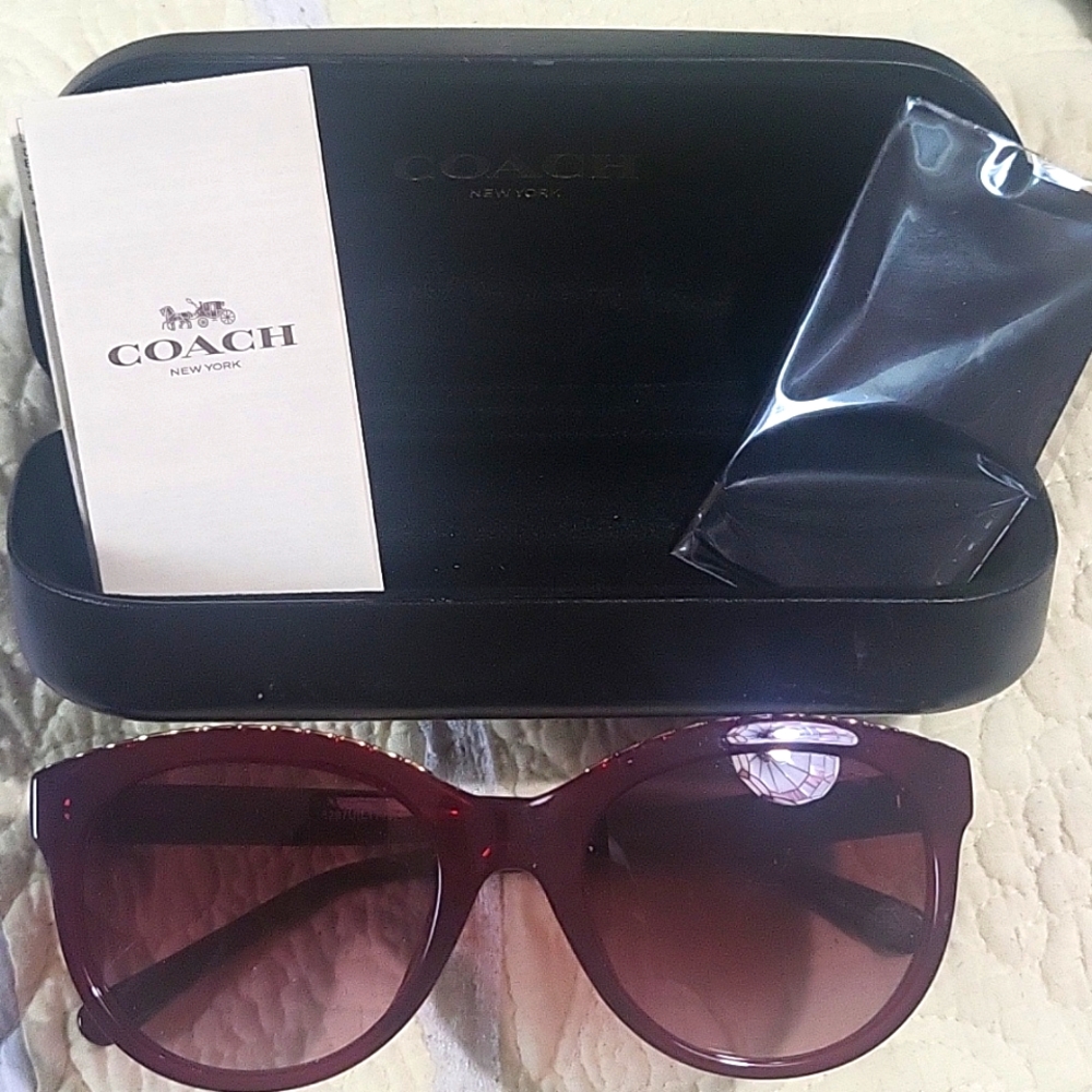 Women's red coach sunglasses in the box with gold chains on the top of the eye